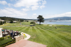 A view of the outside restaurant, green grass of the gold course and the blue ocean, Pebble Beach CA.